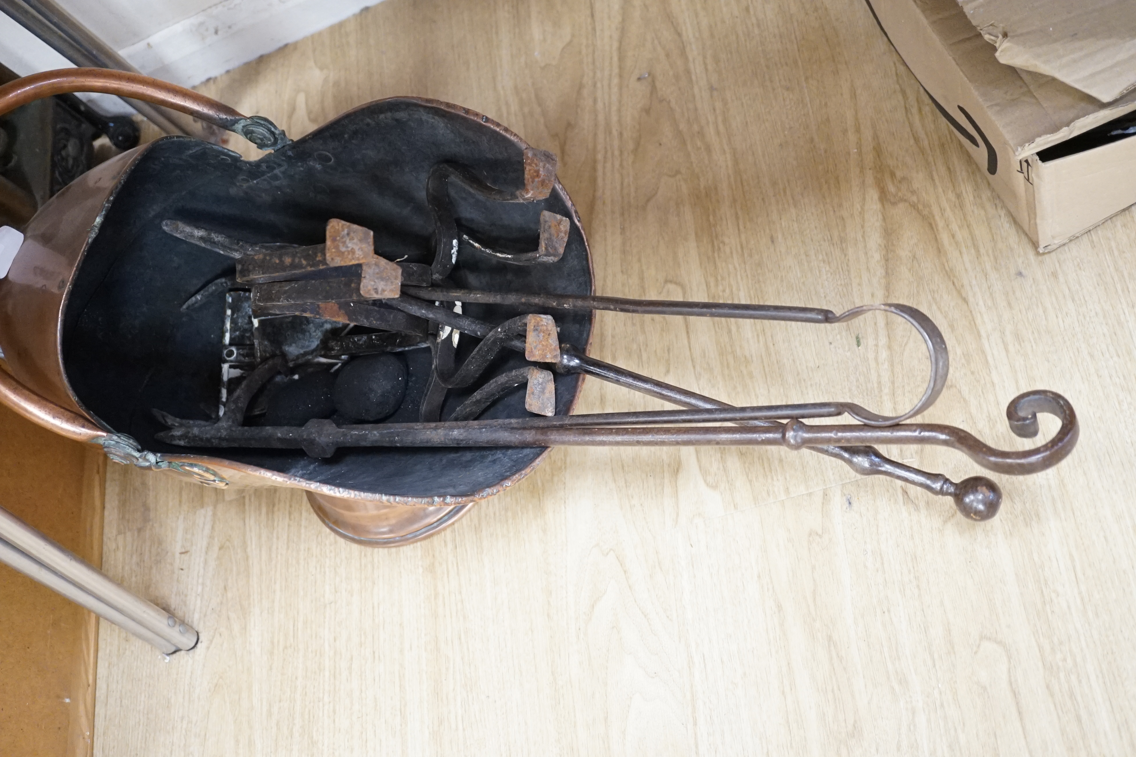 A pair of copper shield shaped fire dogs in Arts & Crafts style, together with further fireside effects